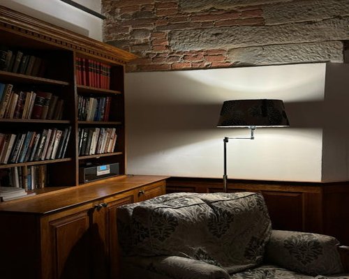 Cozy reading corner with bookshelf and a warm adjustable desk lamp